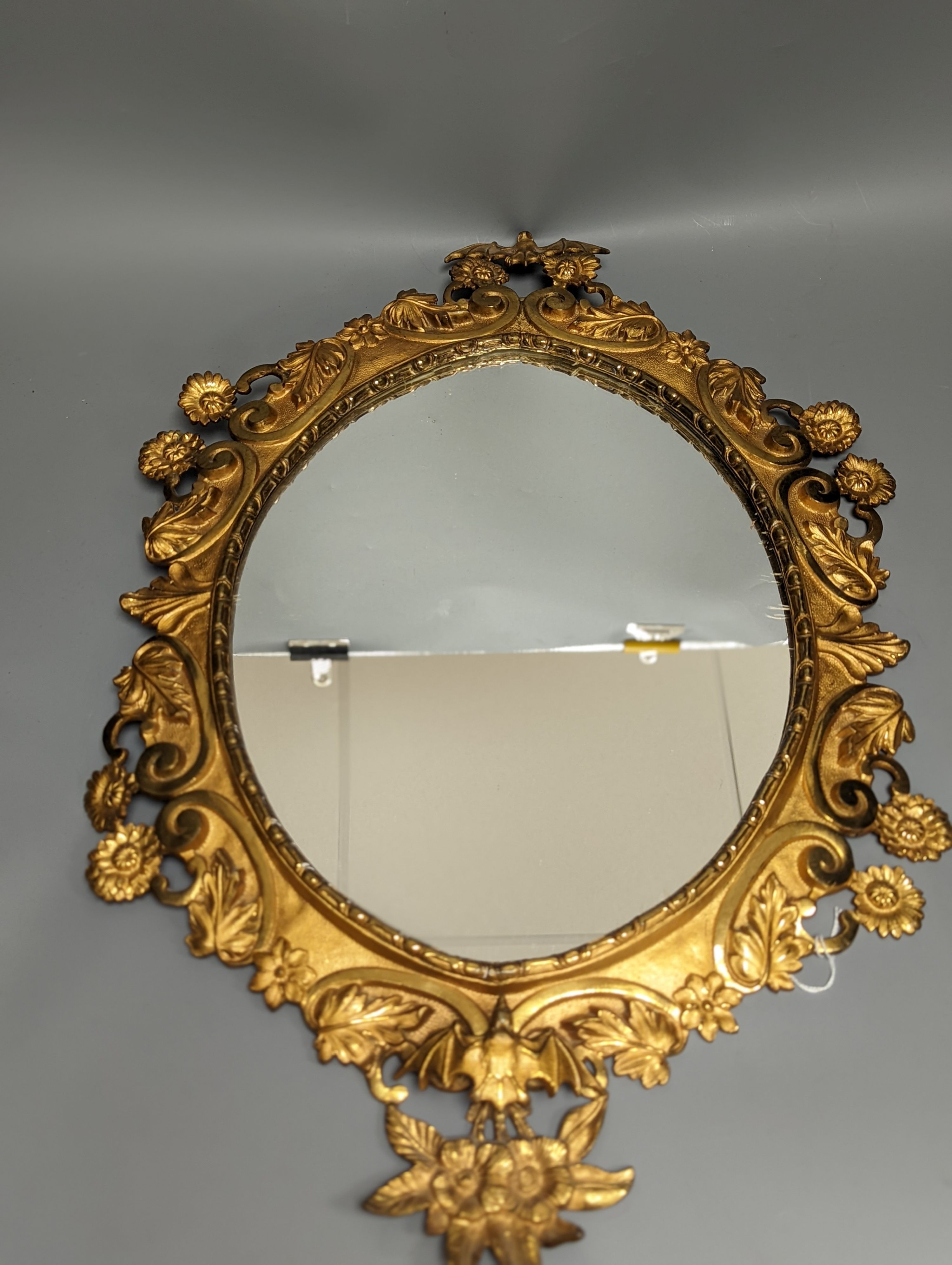 A pair of gilt brass wall mirrors, decorated with bats and flowers 56cm